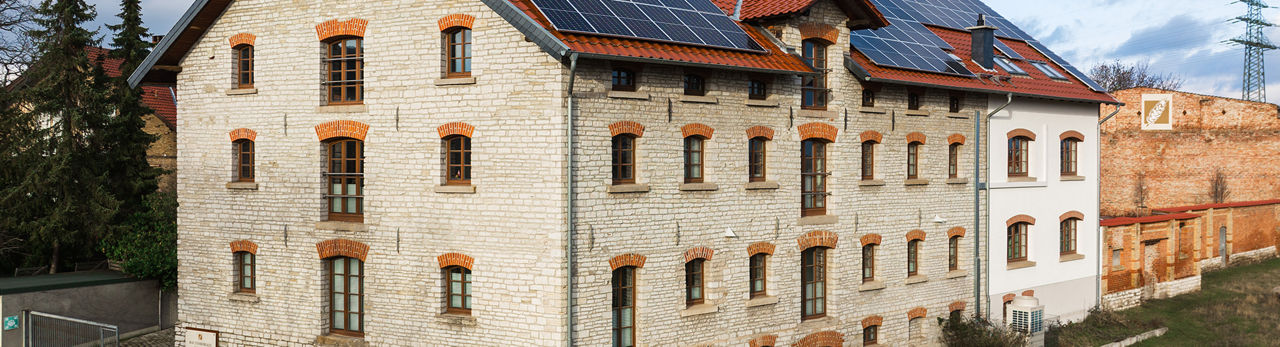 Großes weißes Backsteinhaus mit Solarpanelen auf Dach
