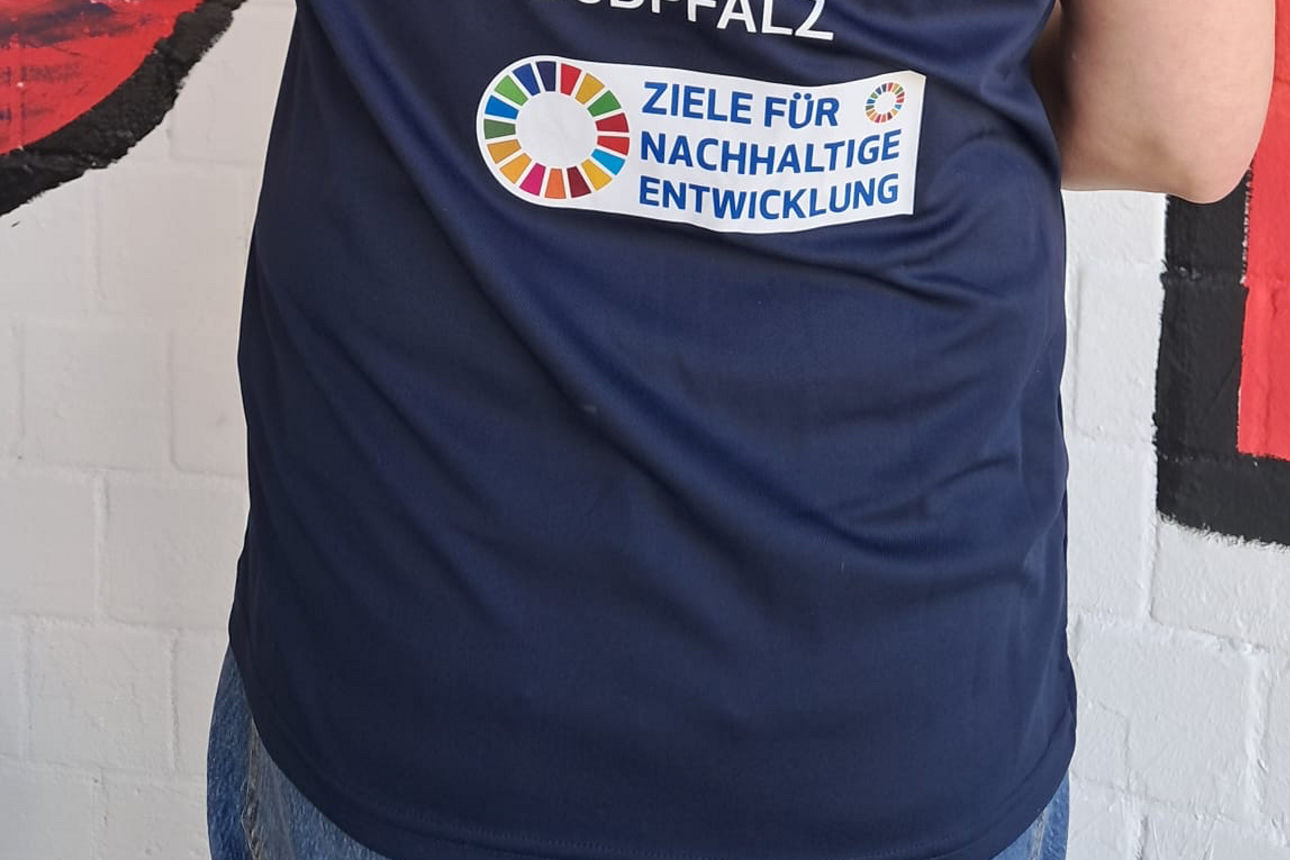 Rücken einer Frau mit Nachhaltigkeitsbotschaft auf dem Shirt