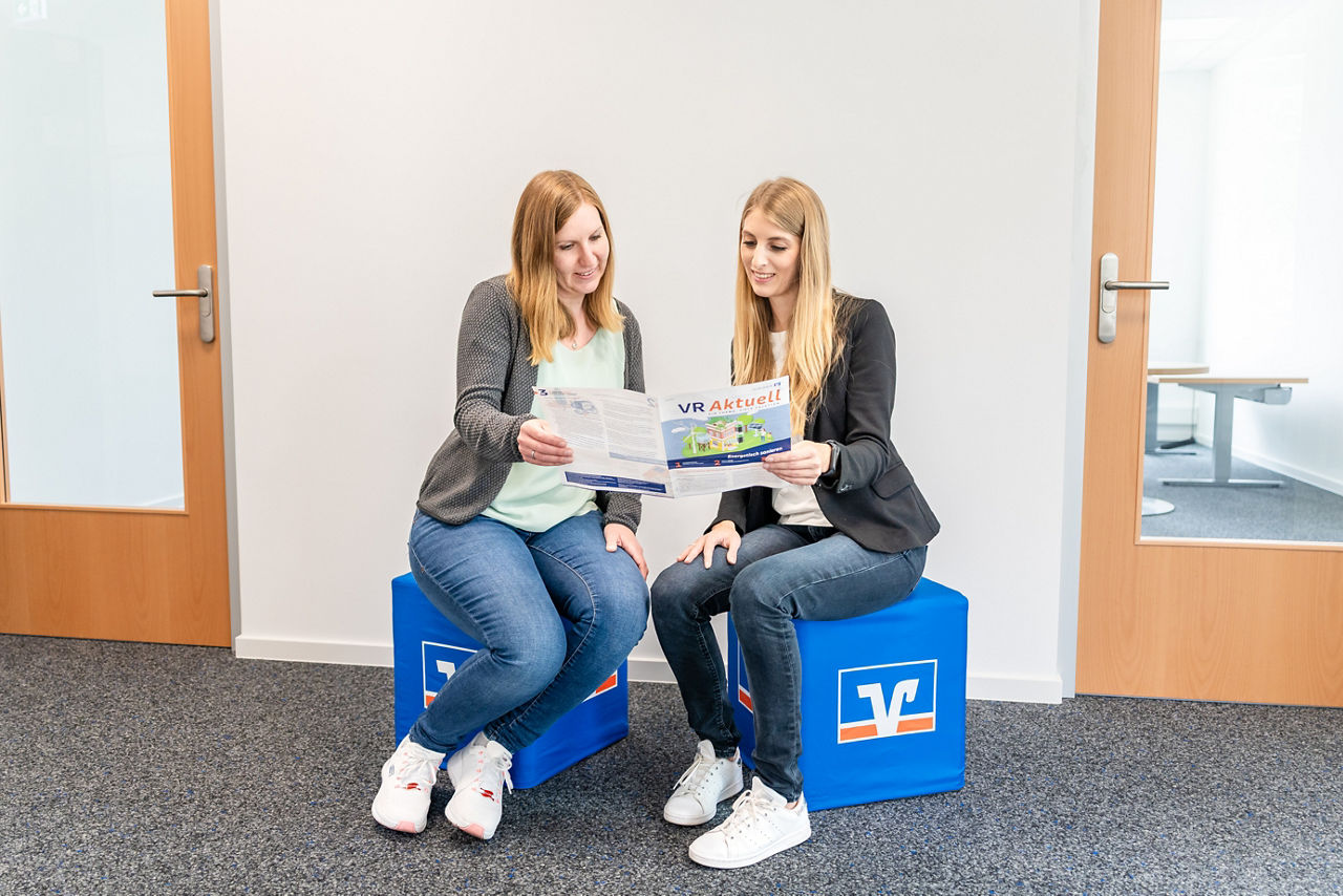 Zwei Frauen schauen sich einen Flyer an
