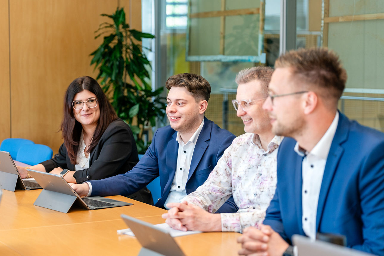 Mitarbeitende sitzen zusammen in einer Besprechung