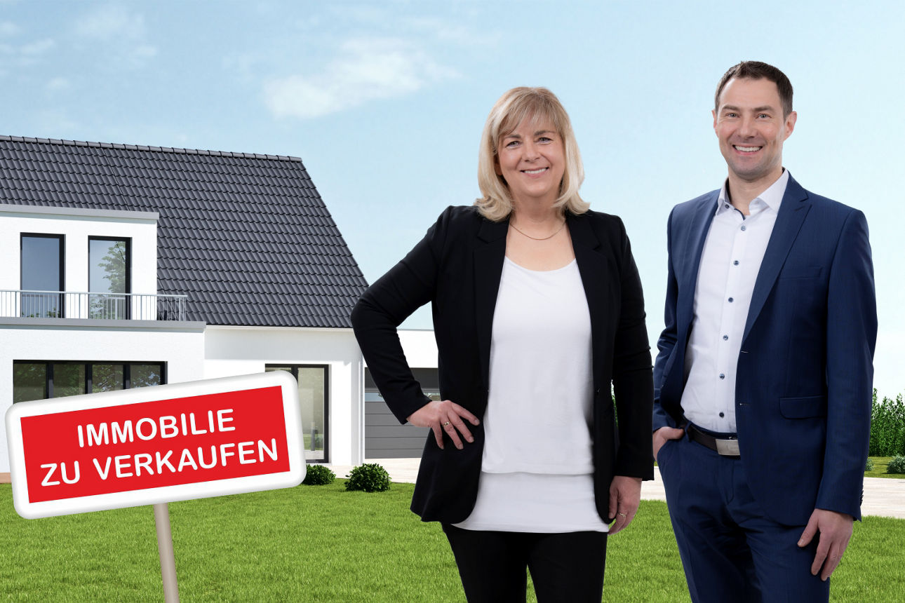 Immobilienvemittler Ilka Hüttner und Ronny Schramm vor einem Einfamilienhaus auf grüner Wiese