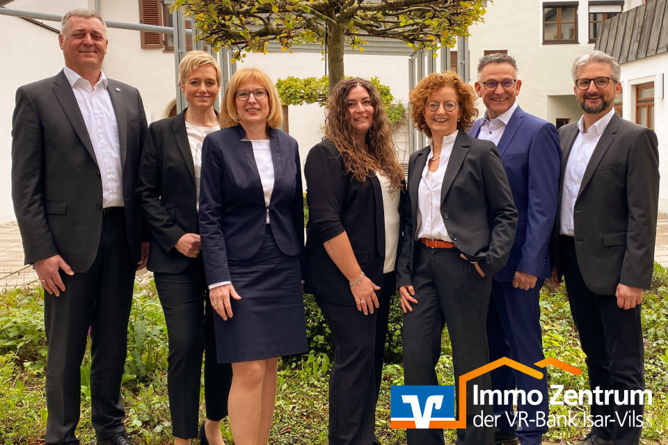 Männer und Frauen vom Immo Zentrum der VR-Bank Isar-Vils stehen nebeneinander und lächeln in die Kamera