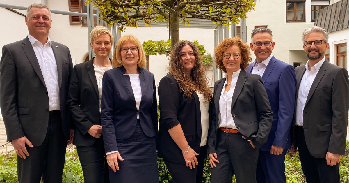 Männer und Frauen vom Immo Zentrum der VR-Bank Isar-Vils stehen nebeneinander und lächeln in die Kamera