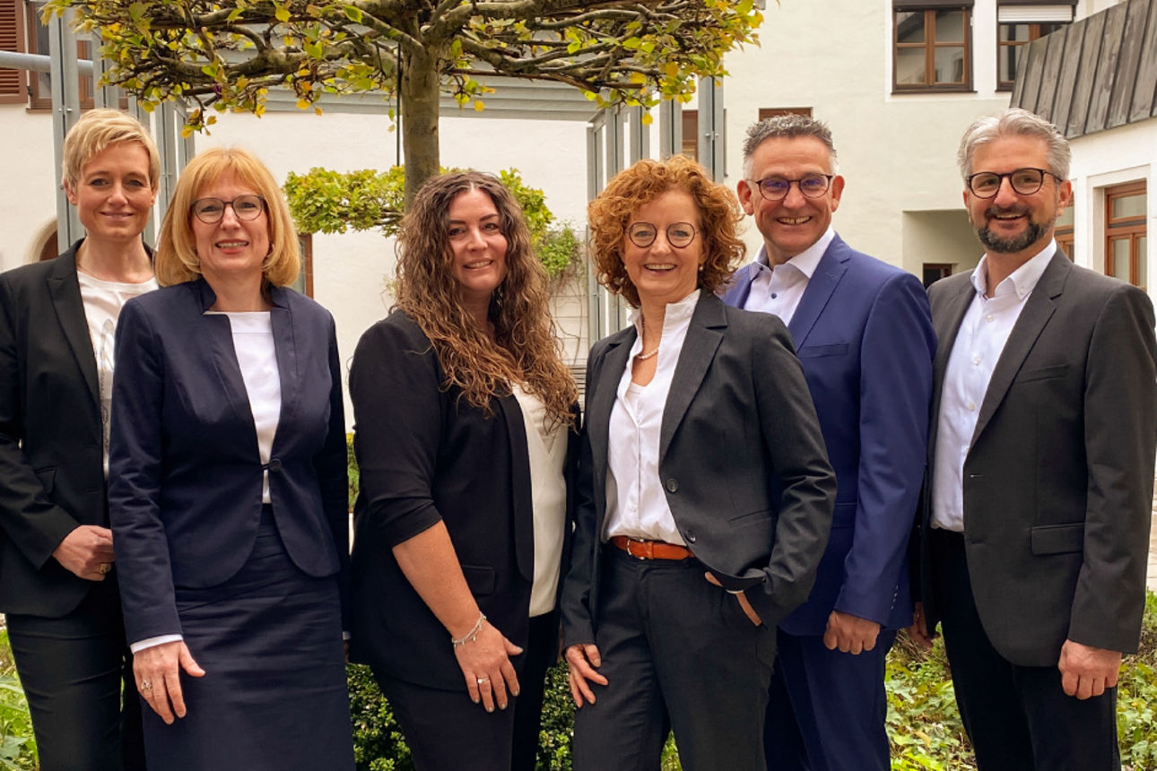 Männer und Frauen vom Immo Zentrum der VR-Bank Isar-Vils stehen nebeneinander und lächeln in die Kamera