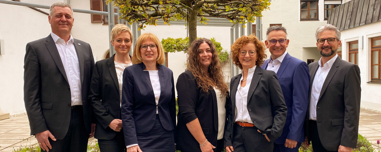 Männer und Frauen vom Immo Zentrum der VR-Bank Isar-Vils stehen nebeneinander und lächeln in die Kamera