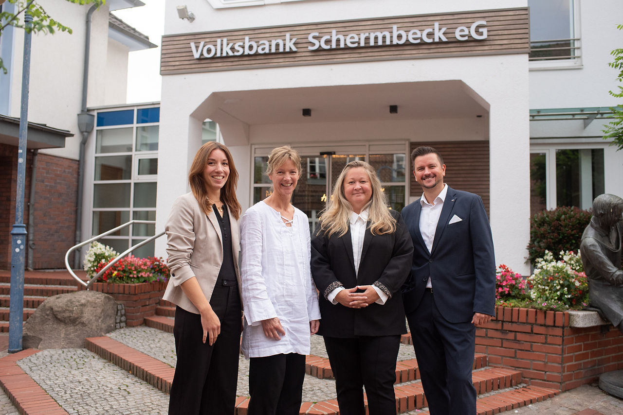Unser Volksbank Schermbeck Immobilienteam bestehend aus drei Frauen und einem Mann vor dem Gebäude der Volksbank Schermbeck.