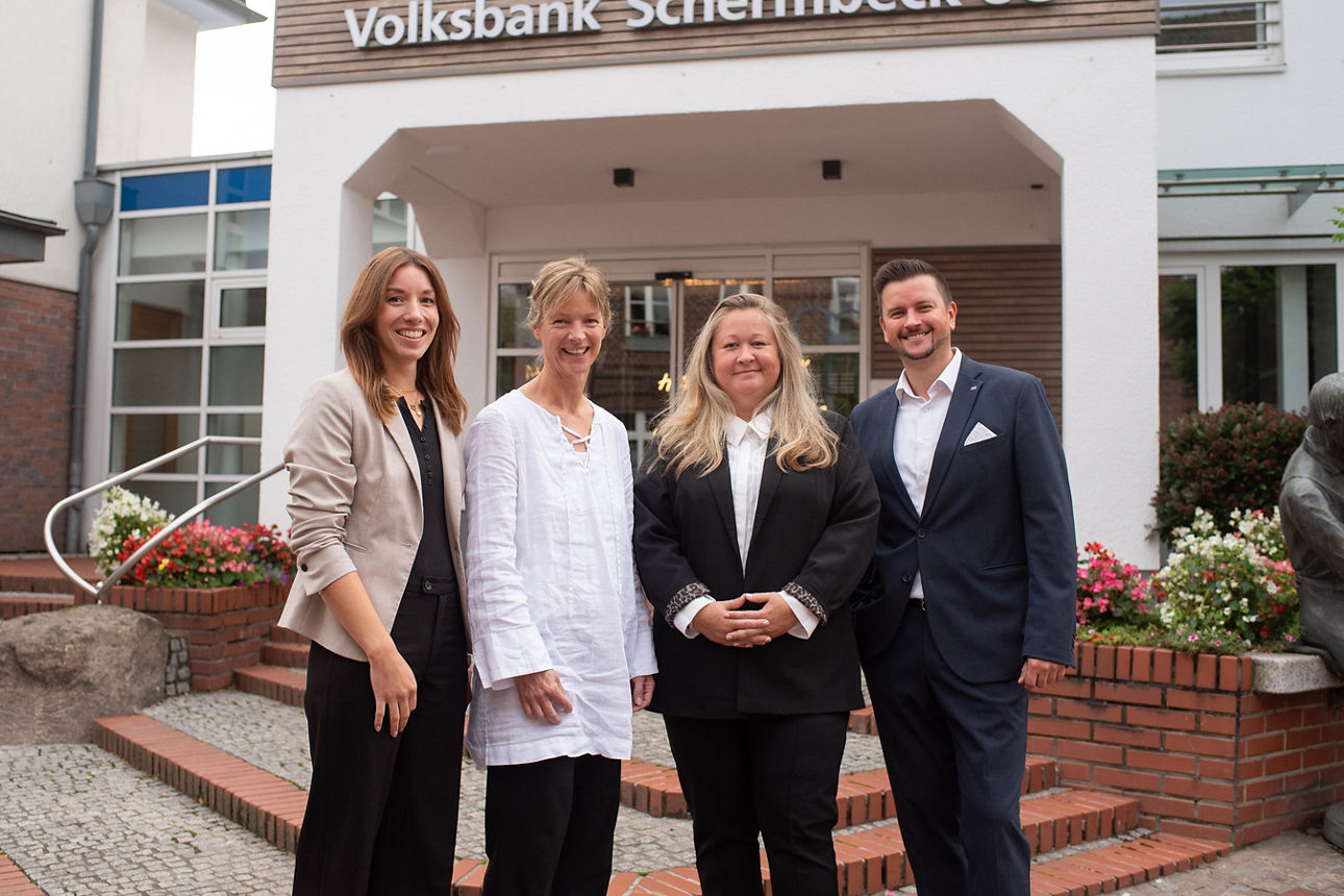 Unser Volksbank Schermbeck Immobilienteam bestehend aus drei Frauen und einem Mann vor dem Gebäude der Volksbank Schermbeck.