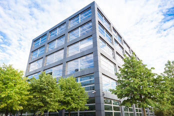 Ein Bürogebäude steht zwischen Bäumen