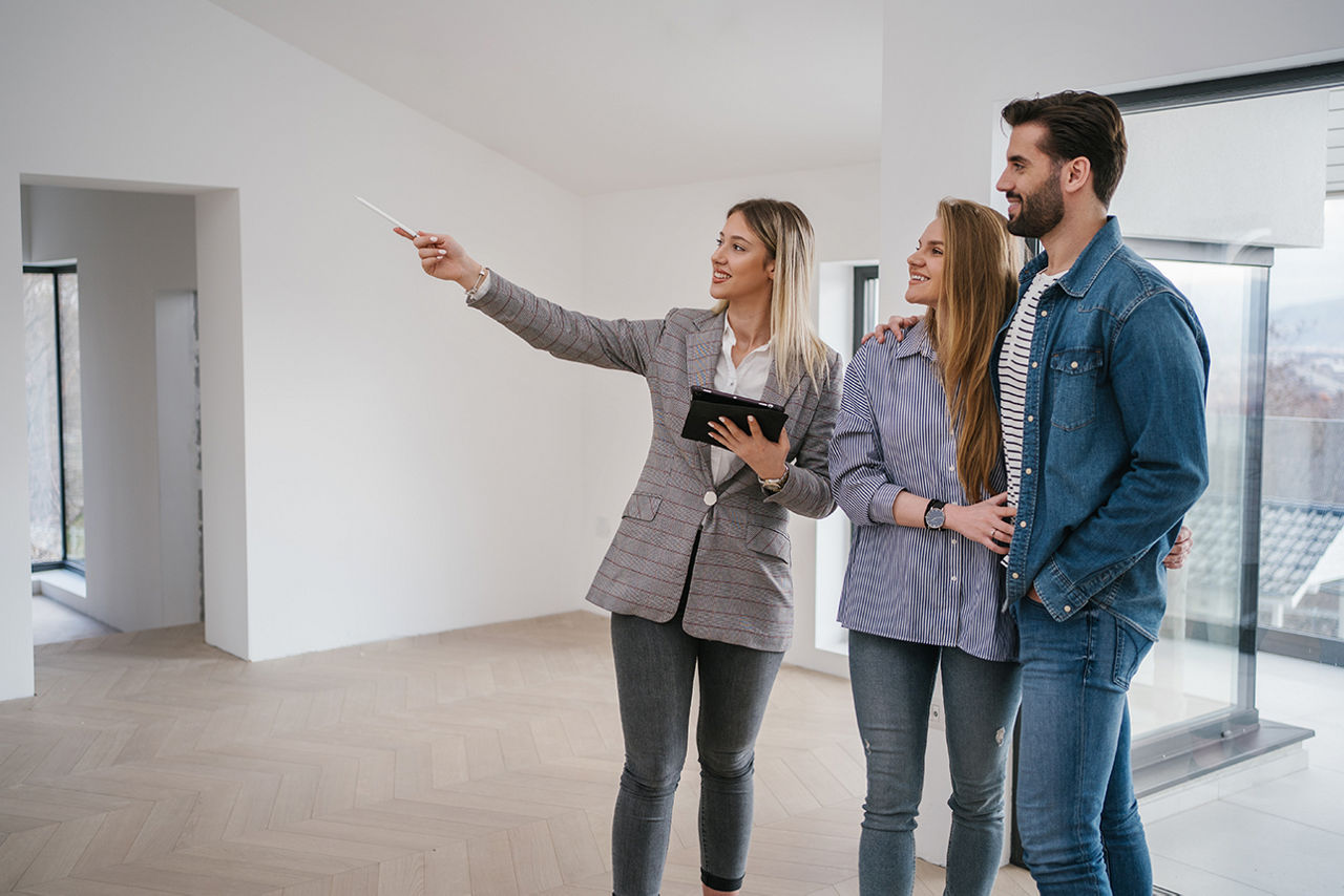 Maklerin zeigt jungem Paar eine Wohnung
