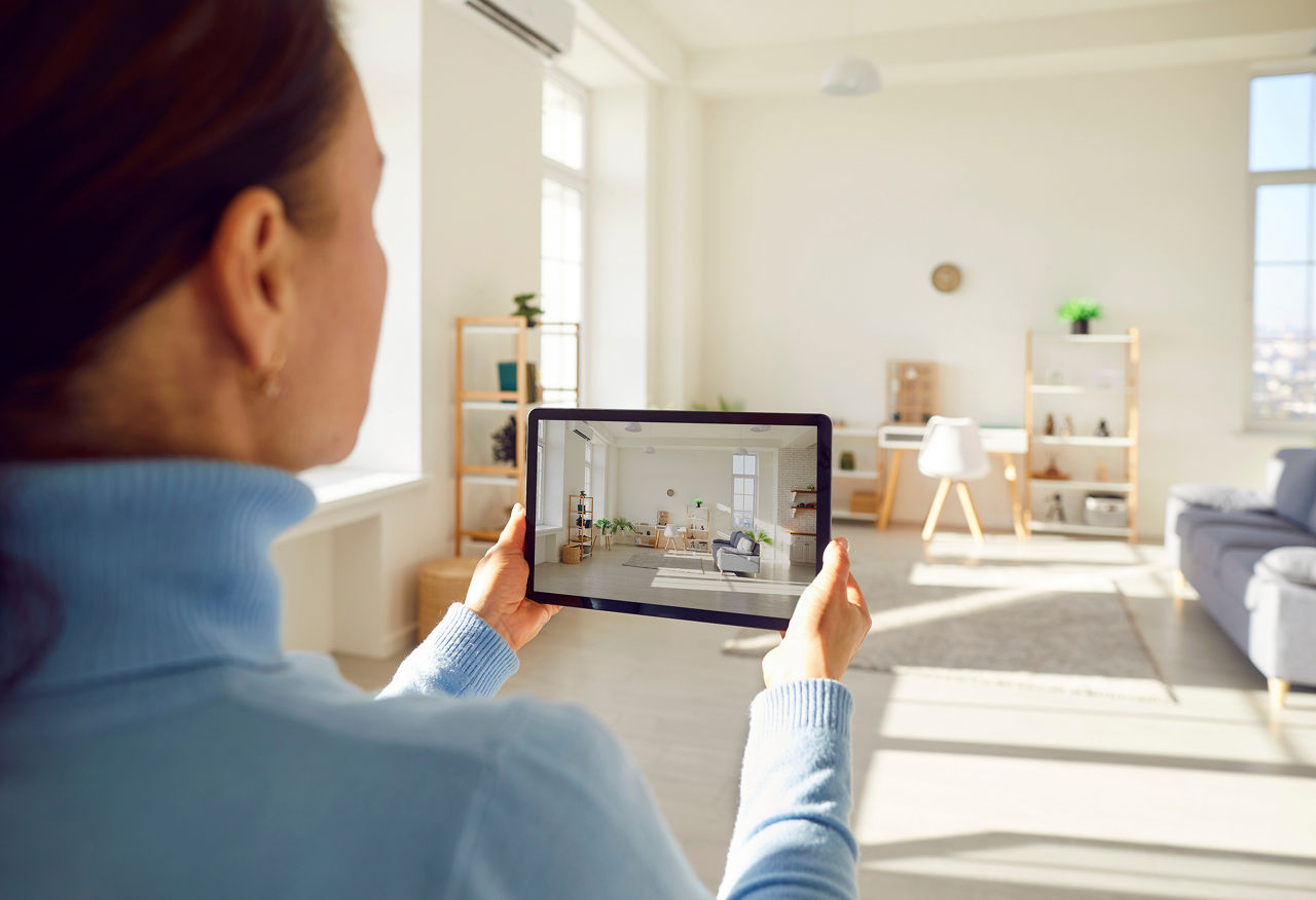 Frau scannt mit einem Tablet ein Wohnzimmer ab um den Raum zu messen