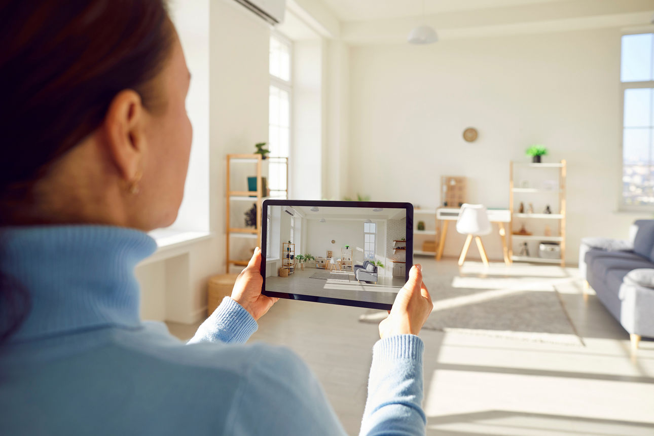 Frau scannt mit einem Tablet ein Wohnzimmer ab um den Raum zu messen