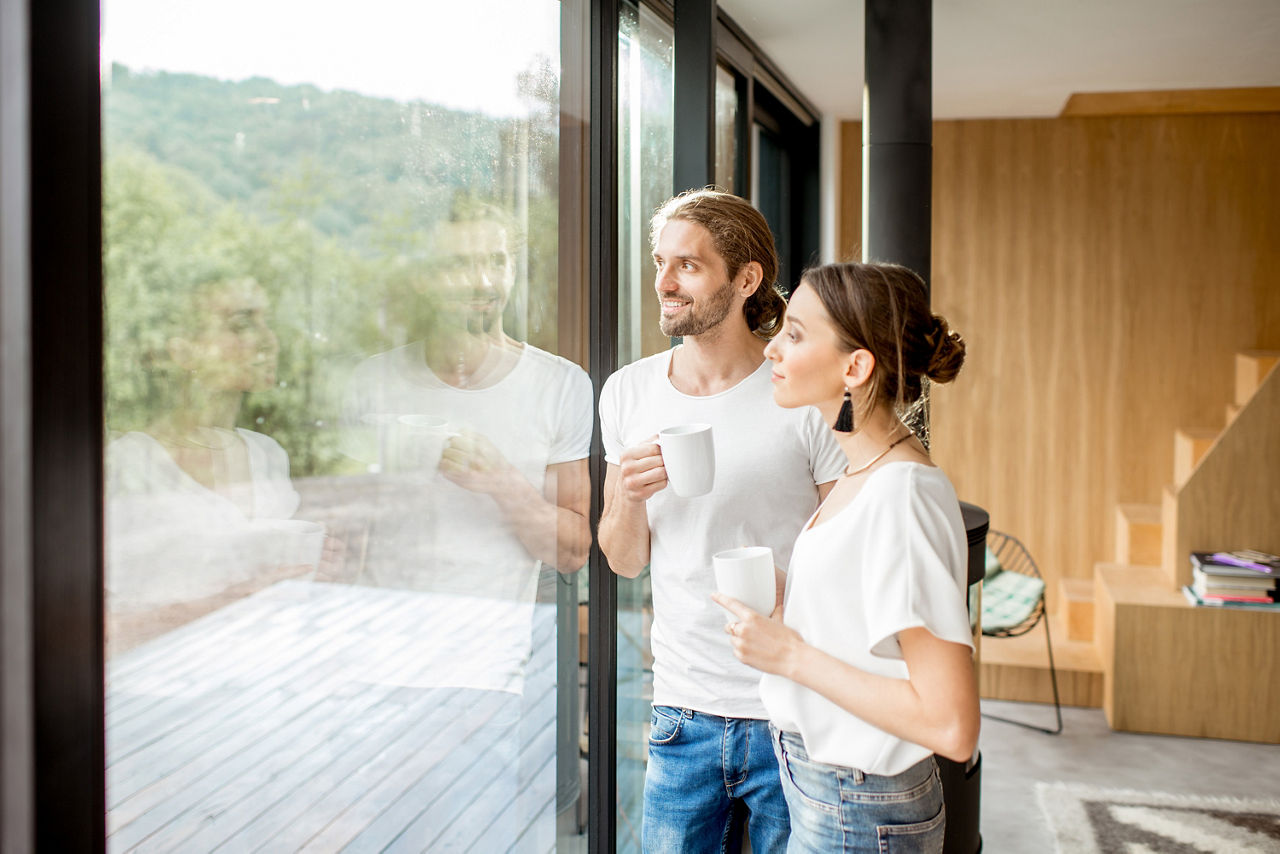 Ein Pärchen steht am Fenster und blickt nach draußen