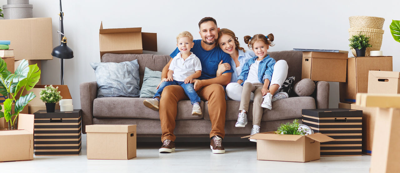 glückliche Familie, Mutter, Vater und Kinder ziehen in eine neue Wohnung und packen Kisten aus
