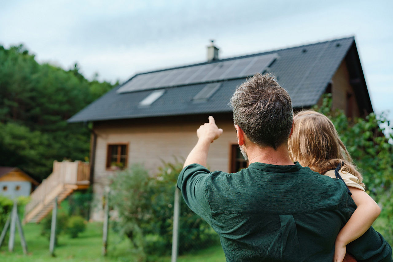 Ein Pärchen steht vor ihrem neu gebauten Haus