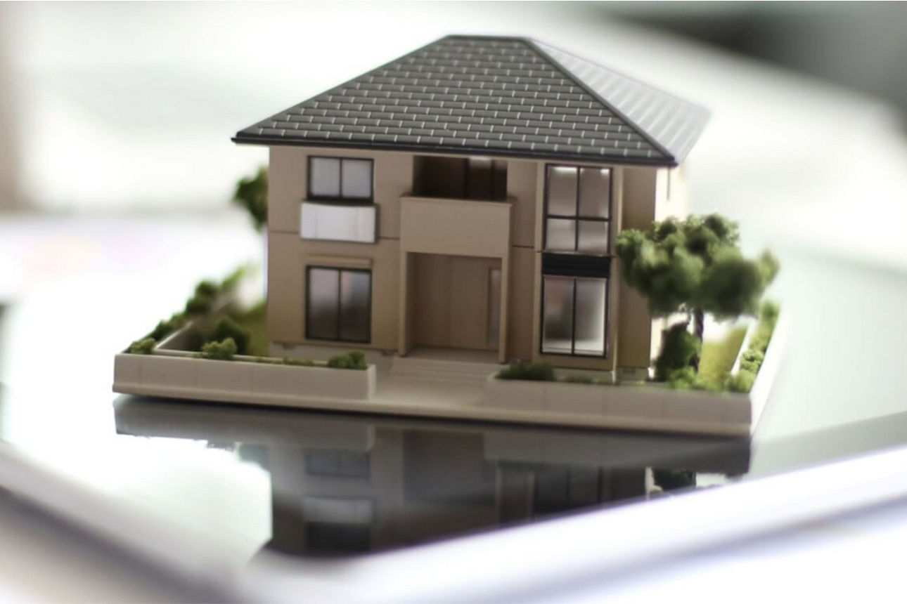 Modell eines Einfamilienhaus steht auf einem IPad