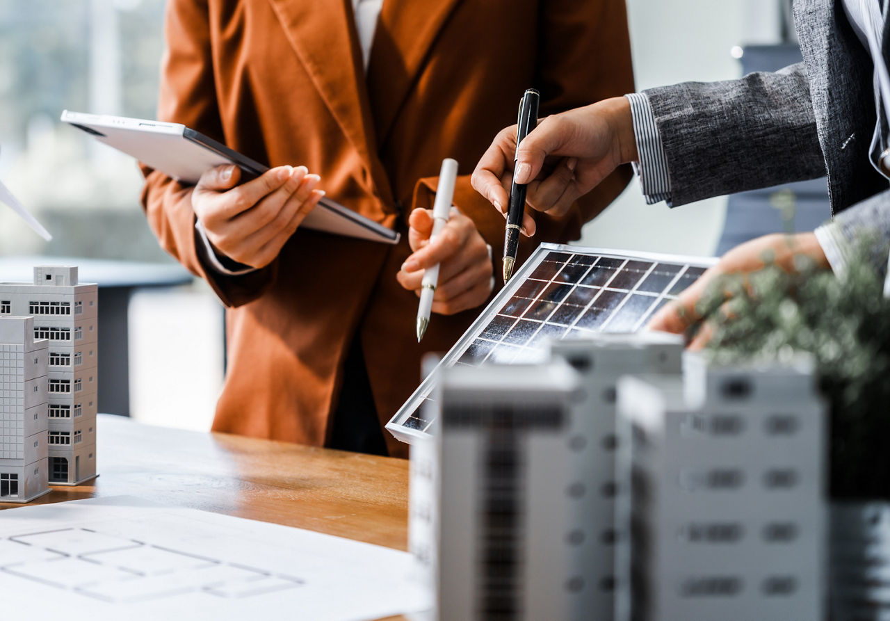 Miniatur-Neubauten mit Photovoltaikanlage auf einem Tisch