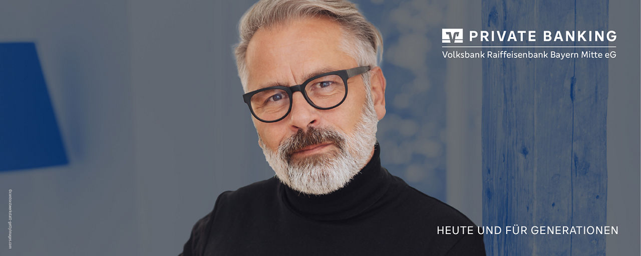 Mann mit Brille schaut auf das Modell einer Immobilie