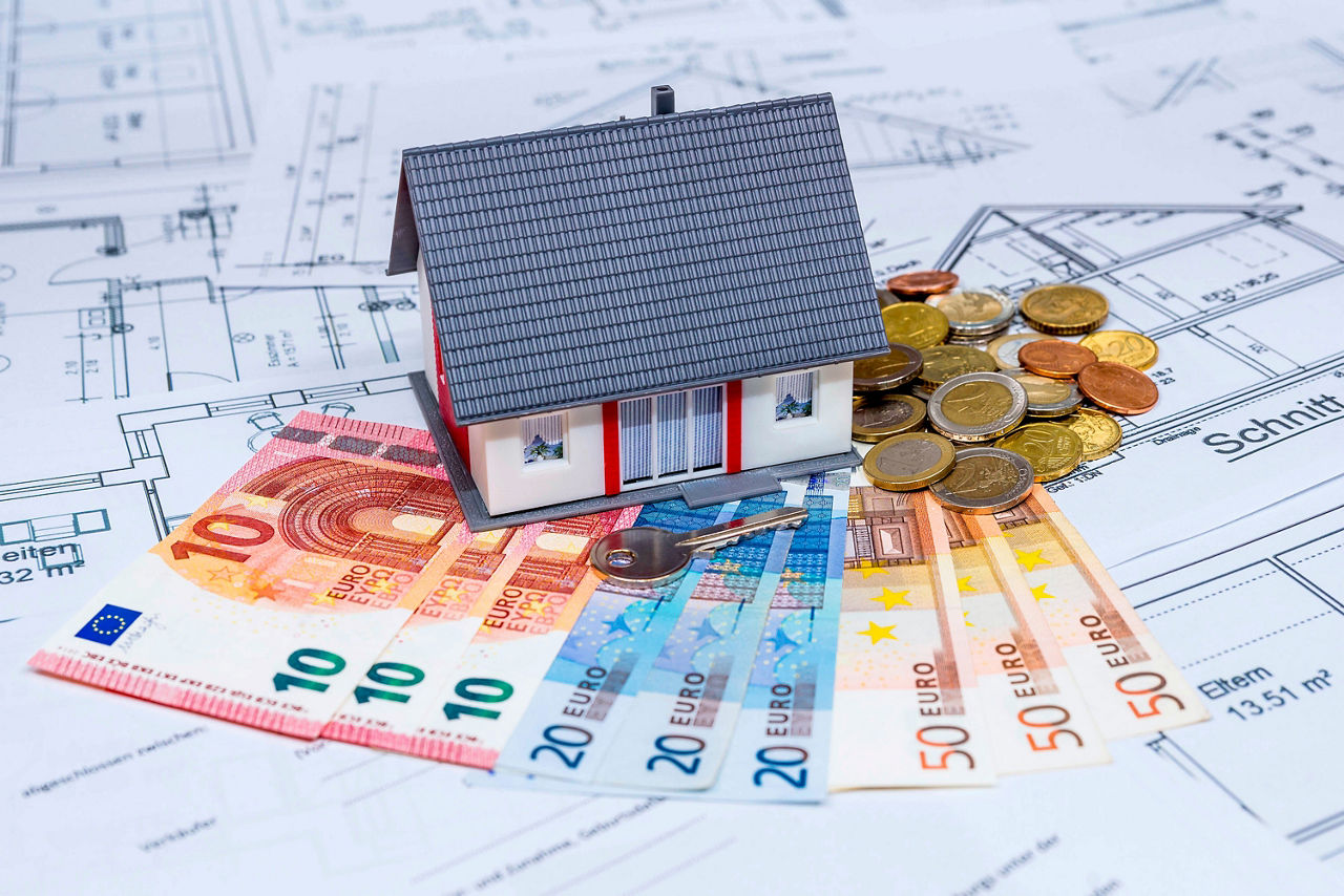 Modell eines Hauses steht auf Geldscheinen