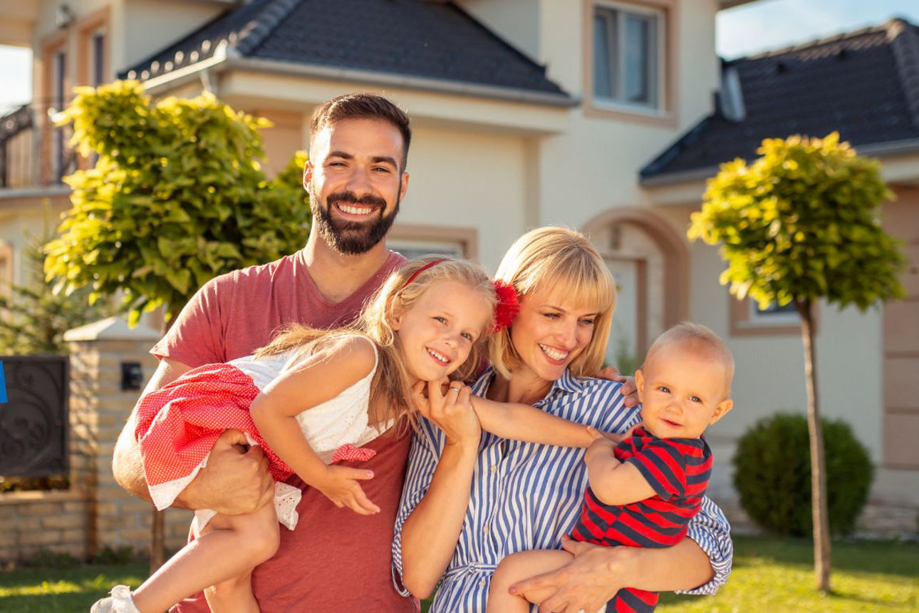 Junge Familie vor einem Haus