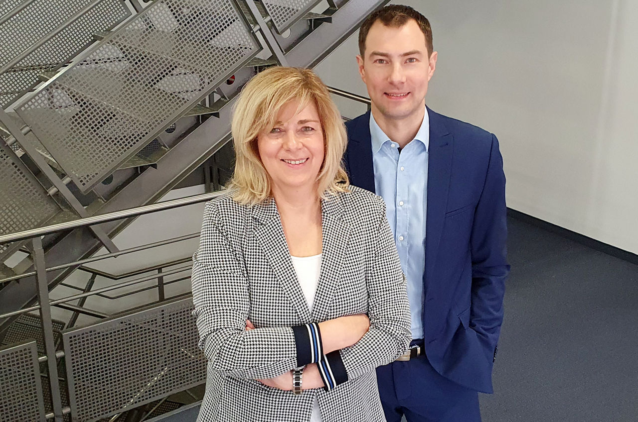Immobilienvermittlerin und -vermittler der Bank stehen vor einer Treppe