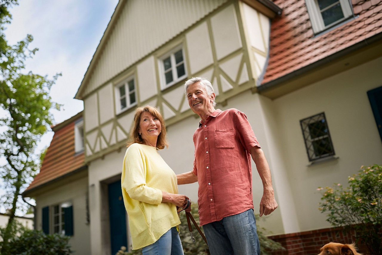 Frau und Mann stehen vor einem Haus