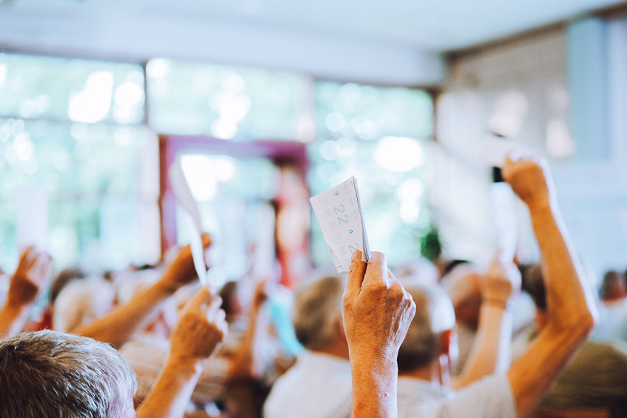 Viele Menschen halten Stimmzettel in die Luft