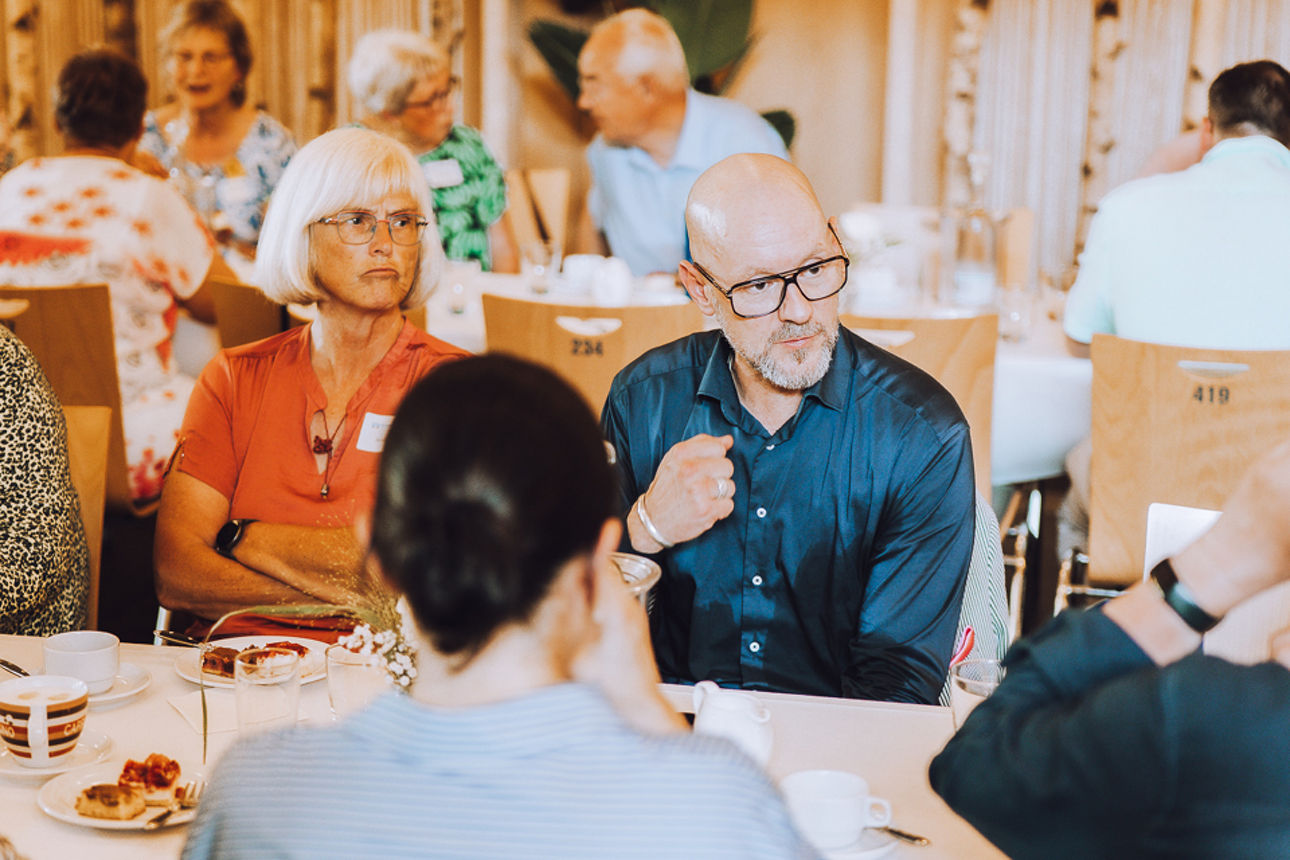 Einige Personen beim Kaffeklatsch am Tisch