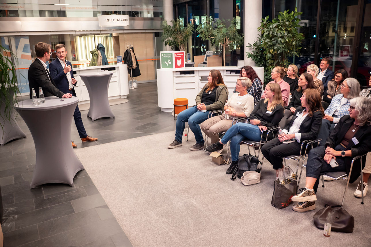 Zwei Referenten mit Gästen in der Netzwerklounge VR Bank Fulda