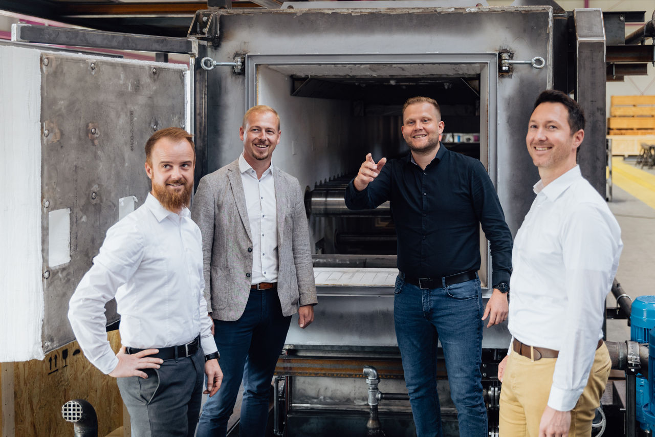 Philipp Seifert, Florian Abschütz, Thomas Kneuer und Florian Graf stehen vor einem Industrieofen