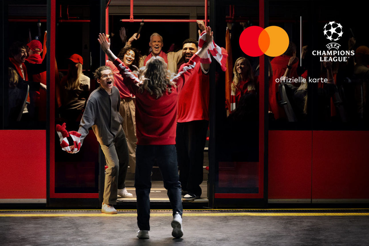 Mann läuft strahlend auf einen Bus zu und wird von Freunden empfangen