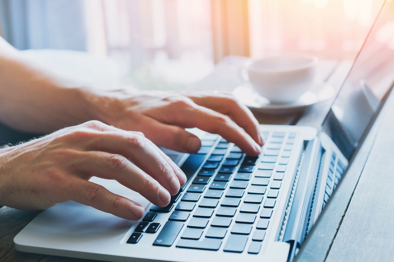 Hände schreiben auf Tastatur vom Laptop