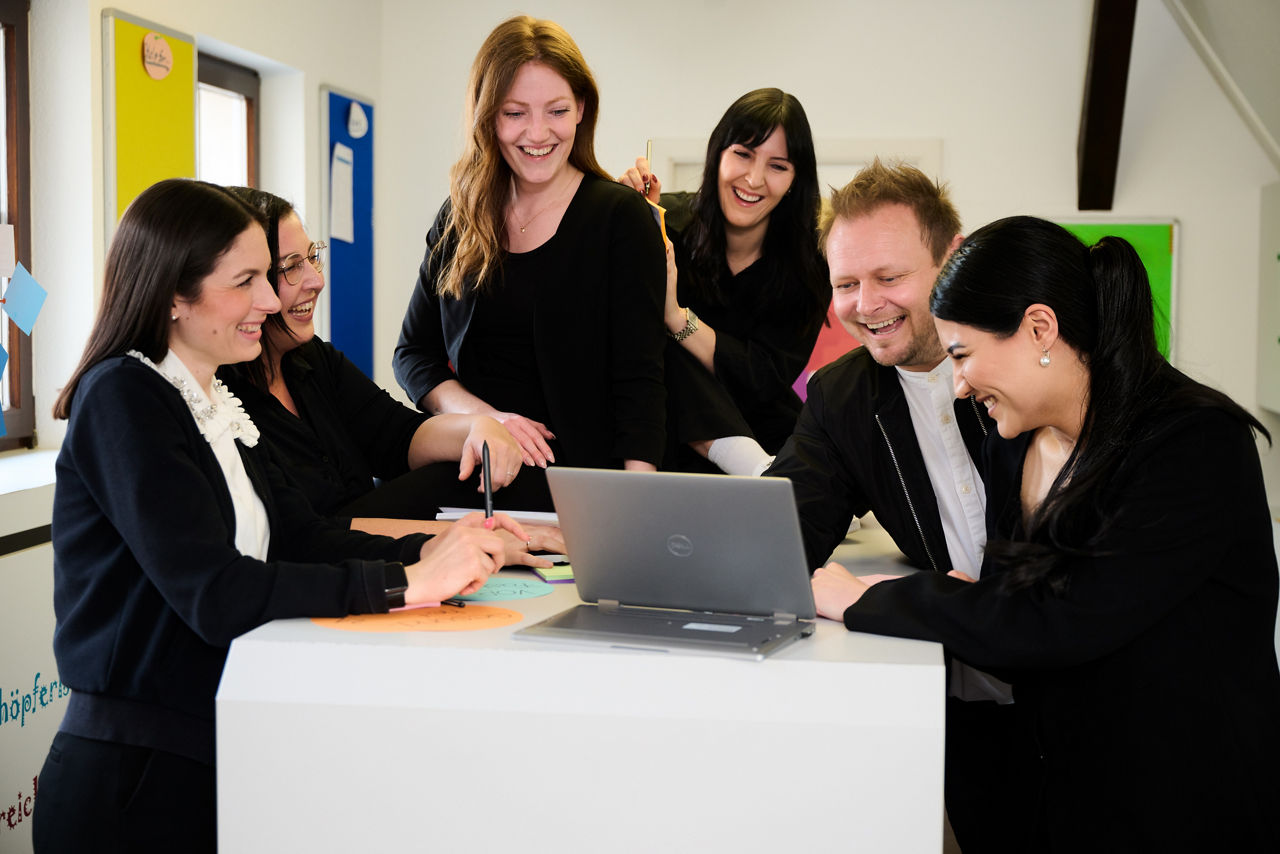 Gruppe mit 6 Personen am Schreibtisch