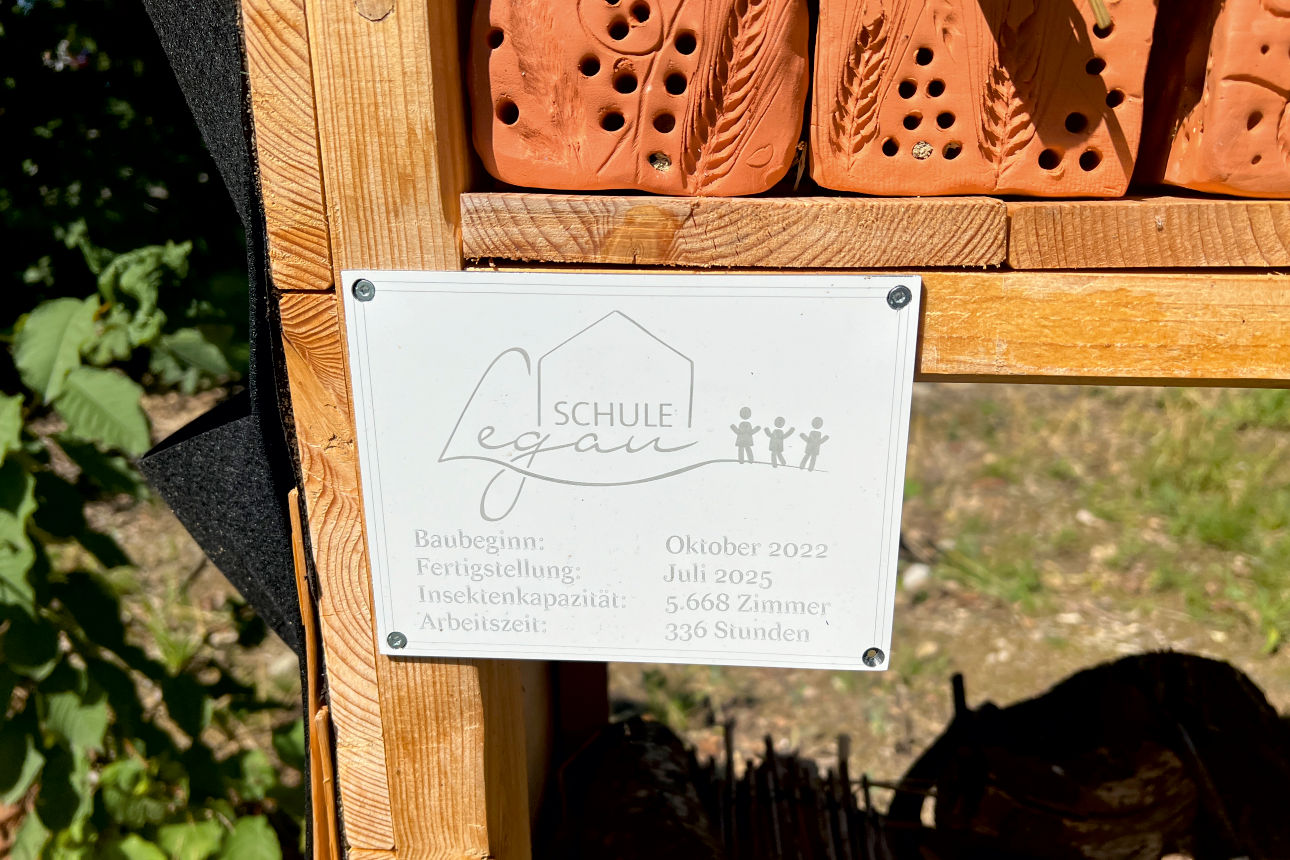 Schild mit Logo der Schule und Arbeitsstunden der Schüler