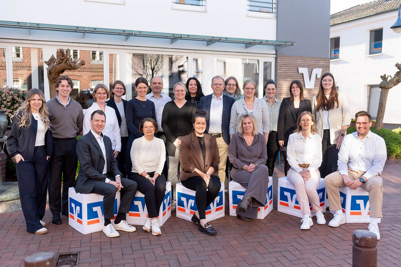 Eine Gruppe von Frauen und Männern steht auf dem Platz vor der Volksbank Schermbeck