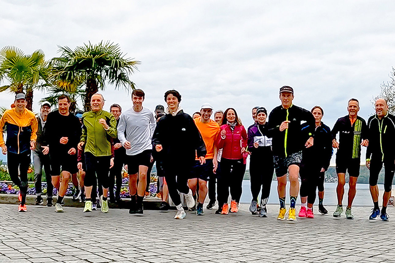 Eine Gruppe Läuferinnen und Läufer beim Lauftraining mit lächelnden Gesichtern.