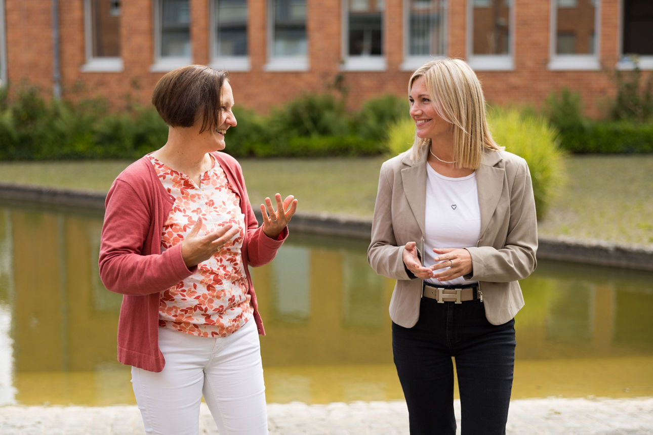 Zwei Frauen unterhalten sich draußen.