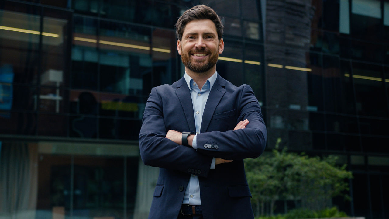 Business owner portrait outdoor confident man Caucasian businessman smiling guy male leader broker trader investor salesman employer in suit hands crossed in city downtown smiling looking at camera. High quality 4k footage