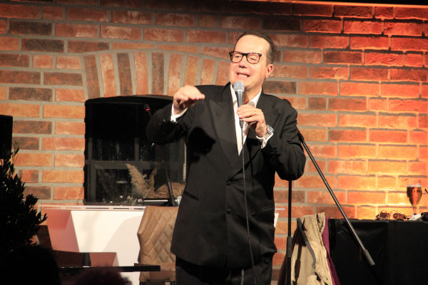 Kabarettist Jörg Hammerschmidt hält ein Mikrofon und spricht hinein
