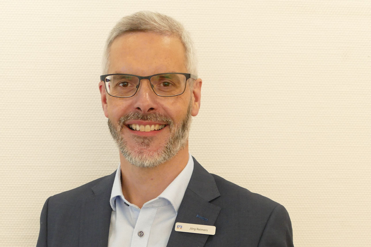 Ein Mann lächelt in die Kamera