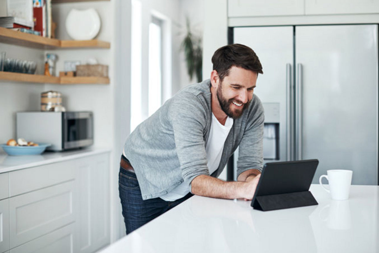 Mann informiert sich am Tablet über Tagesgeldzinsen