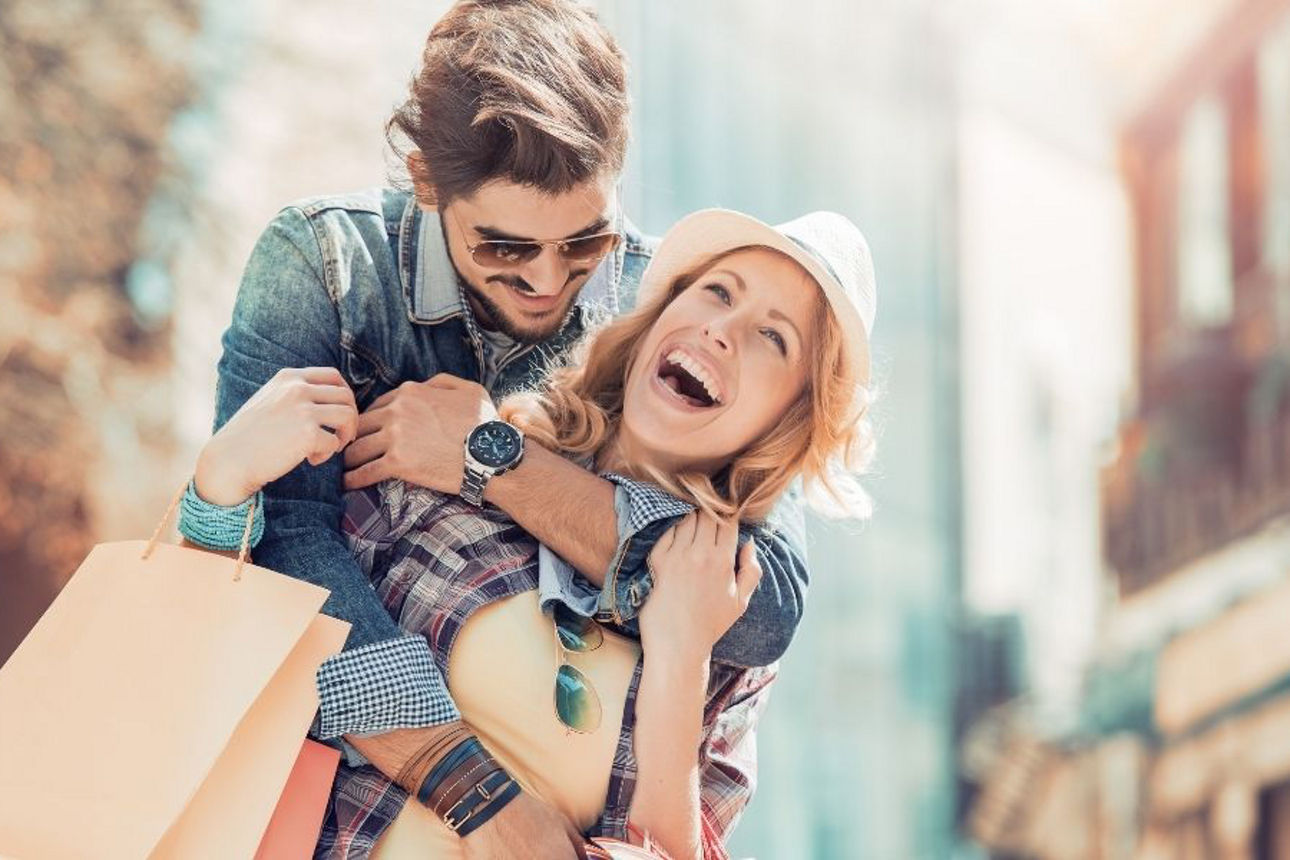 Junges Liebespaar freudestrahlend auf der Shoppingtour
