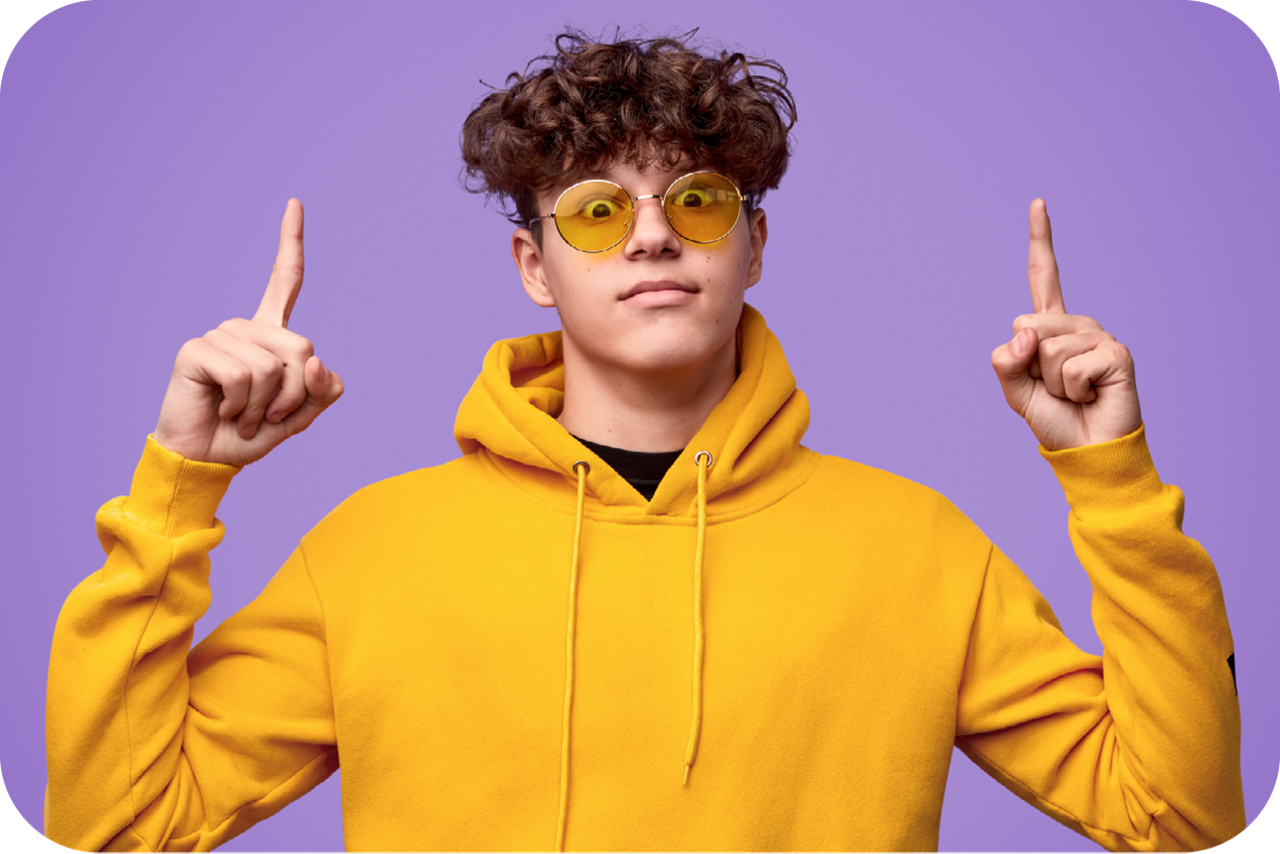 Photo of young schoolboy pointing in the sky isolated on purple background