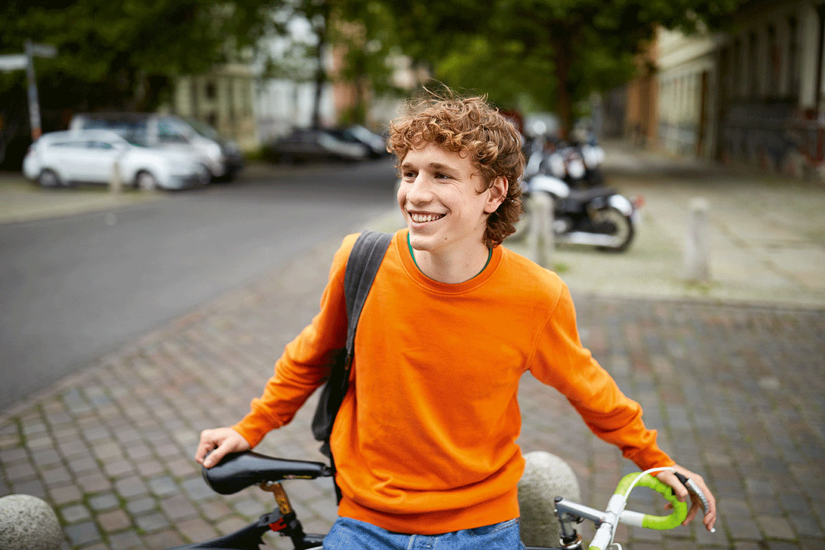 Jugendlicher lehnt an seinem Fahrrad