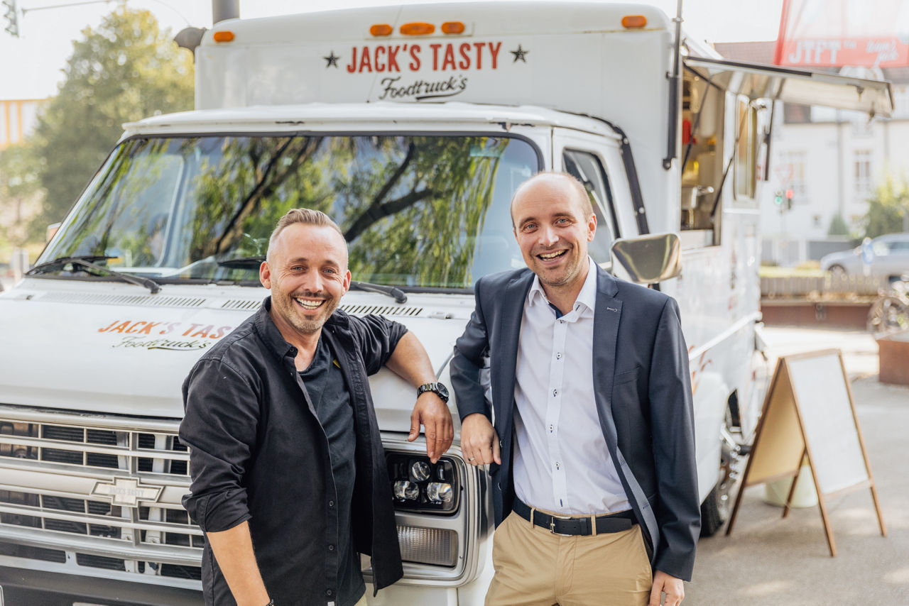Inhaber Christian Kohl und Bankberater Marco Müller im Austausch vor dem Foodtruck von Jack’s Tasty Foodtrucks.