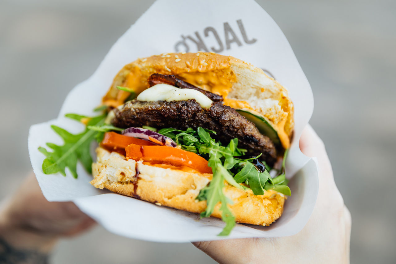 Frisch zubereiteter Burger von Jack’s Tasty Foodtrucks mit knackigem Gemüse und hausgemachten Zutaten.