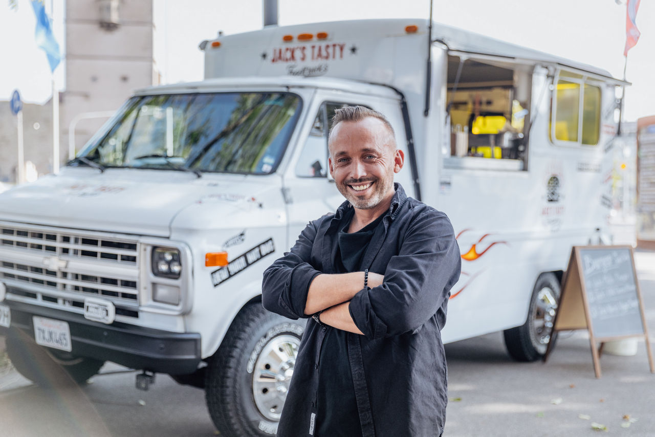 Foodtruck von Jack’s Tasty Foodtrucks bei einem Außeneinsatz, davor Inhaber Christian Kohl in Arbeitskleidung.