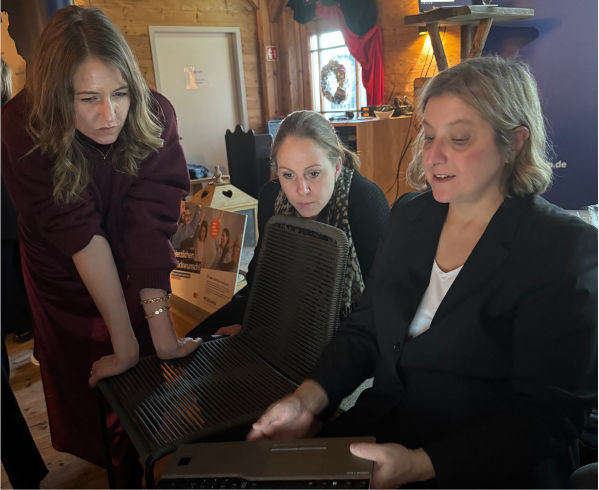 Prof. Dr. Welpe zeigt den Mitarbeitern KI Tools an Ihrem Laptop
