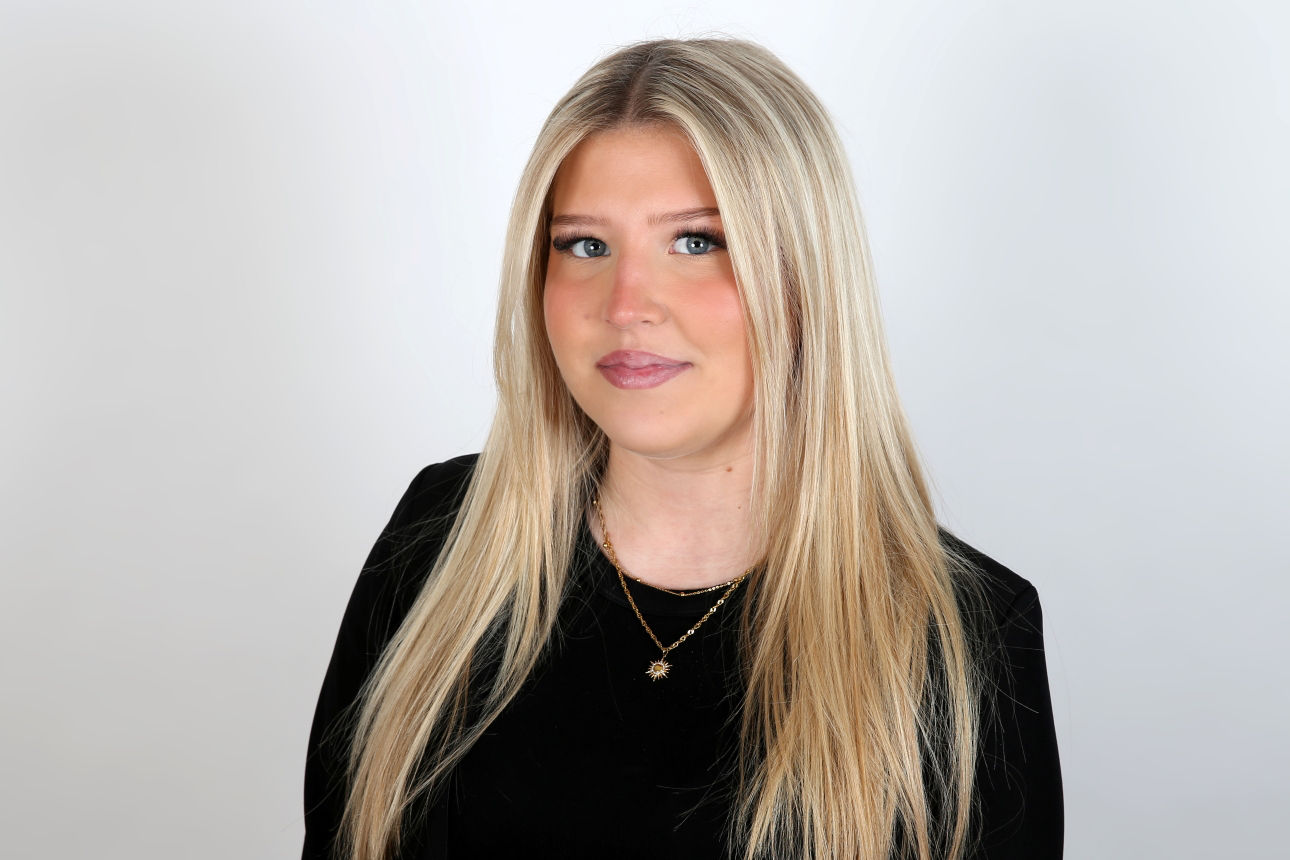 Eine lächelnde Frau schaut in die Kamera.