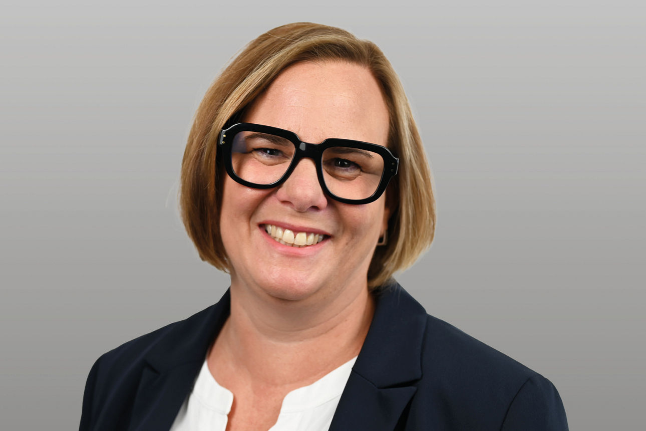 Servicemitarbeiterin Nina Jensen-Kusk vor grauen Hintergrund