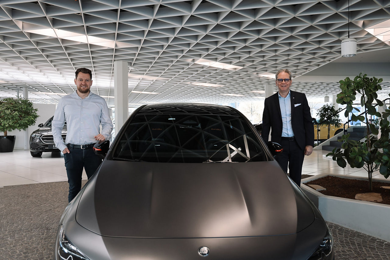 Felix und Joachim Dünkel jeweils neben einem Auto stehend